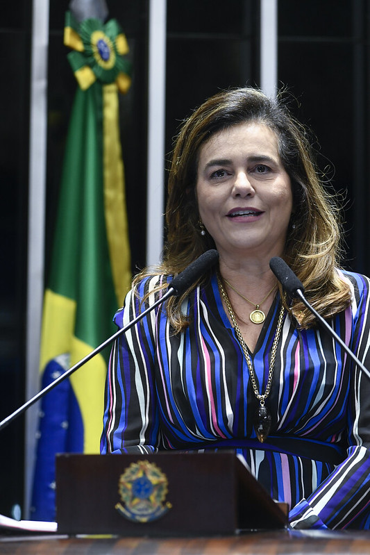 foto vertical de perfil mulher branca cabelo longo falando ao microfone no púlpito. desembargadora federal Mônica Sifuentes.