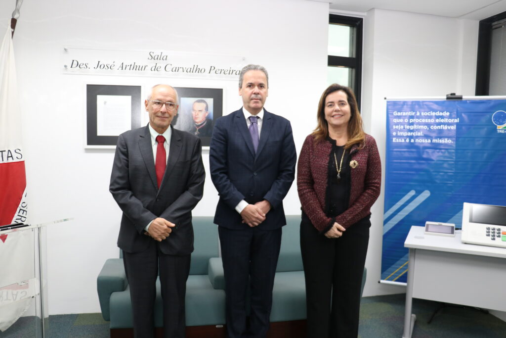 foto horizontal três pessoas em pé em uma sala uma mulher e dois homens. da esq. para dir.: desembargadorricardo mohallem; desembargadora Mônica Sifuentes e desembargador Mauricio soares