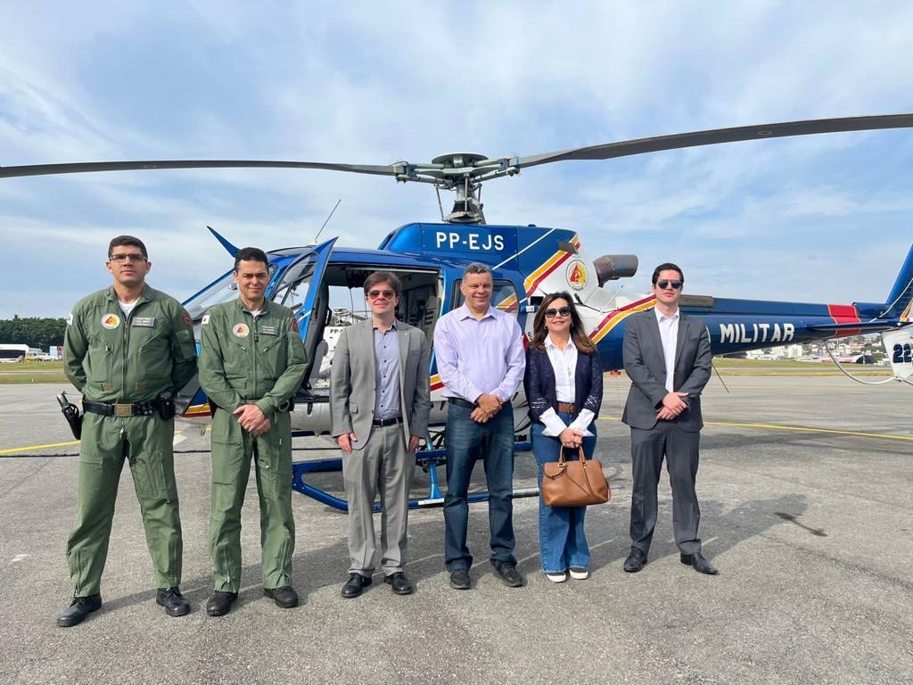 Fotografia horizontal colorida pessoas em pé lado a lado na frente de um helicóptero. Legenda: Autoridades sobrevoaram a região do rompimento da barragem de Fundão