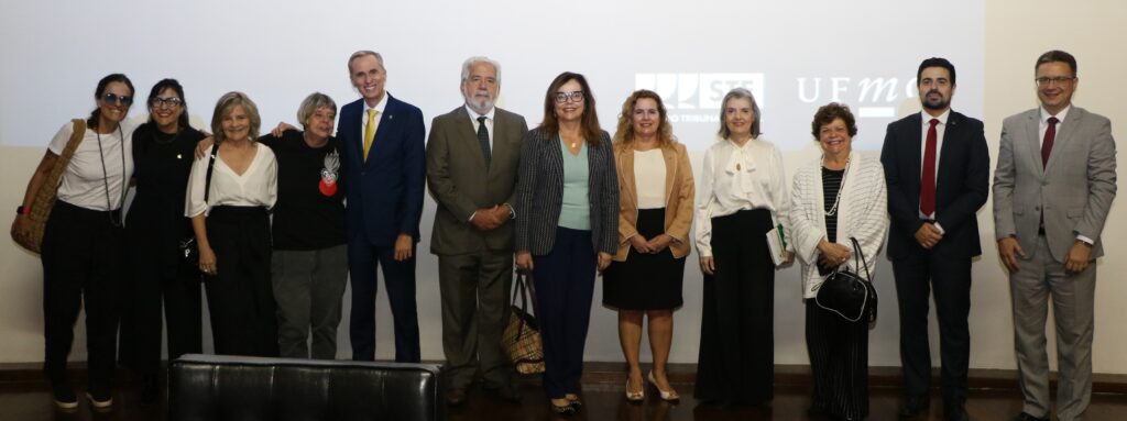 Fotografia vertical colorida com vários homens e mulheres lado a lado. Legenda: Participantes do evento de encerramento da 1ª Jornada do Programa UFMG de
Formação Cidadã em Defesa da Democracia.